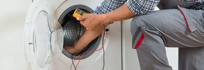 Dryer repair technician inspecting and repairing a clothes dryer in Birmingham, AL