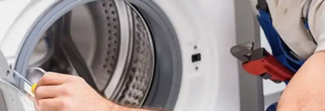 Appliance technician repairing a clothes dryer drum and internal parts in Birmingham, AL