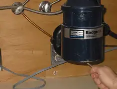 Garbage disposal repair technician tightening the mounting ring under a sink in Birmingham, AL