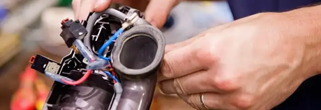 Vacuum repair technician reconnecting wiring and components in Birmingham, AL