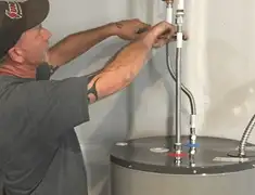 Water heater repair technician tightening supply line connections in Birmingham, AL